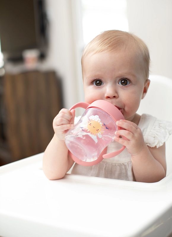 dr. brown's trainingsbeker zachte tuit 180 ml Baby zit in een kinderstoel en drinkt zelfstandig uit een roze trainingsbeker zachte tuit 180 ml met handvatten. Deze trainingsbeker van Dr. Brown, ook gekend als dr brown, helpt bij de overgang van een babyfles met new born transition speen standaardfles naar zelfstandig drinken. De beker ondersteunt baby’s die borstvoeding en voeden met een babyfles combineren en stap voor stap leren drinken uit een tuitbeker.