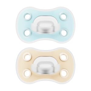 Photo de deux sucettes pour bébé : la sucette en silicone Dr. Brown’s Advantage One Piece, phase 1, disponible en bleu et en crème. Cette sucette en silicone souple de Dr. Brown est dotée d'orifices d'aération dans la coque et peut être utilisée en complément d'un biberon Dr. Brown.